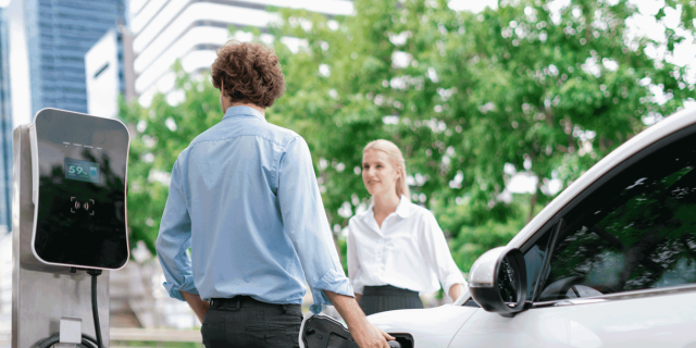 People charging electric vehicle